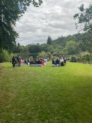 Relaxed atmosphere natural outdoor celebrant wedding ceremony in Scotland with guests gathered in castle garden setting